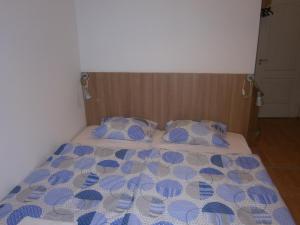 a bed with a blue and white comforter and pillows at Fanni Budapest Guesthouse in Budapest
