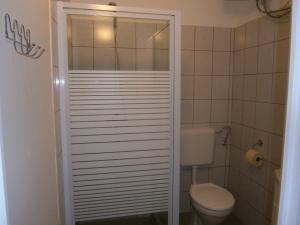 a bathroom with a toilet and a white door at Fanni Budapest Guesthouse in Budapest