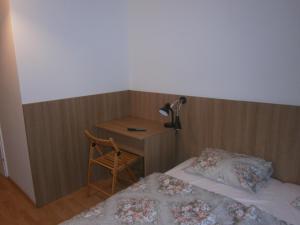 a bedroom with a bed and a desk with a lamp at Fanni Budapest Guesthouse in Budapest