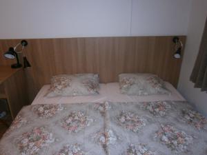 a bedroom with a bed with two pillows and a headboard at Fanni Budapest Guesthouse in Budapest