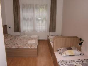 two beds in a small room with a window at Fanni Budapest Guesthouse in Budapest