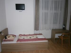 a small room with a bed and a table and a tv at Fanni Budapest Guesthouse in Budapest
