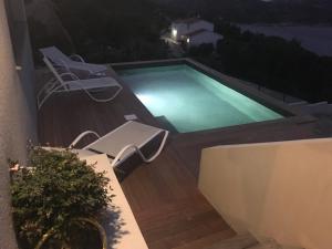 a swimming pool on a deck at night at Villa MAKELE in Calvi