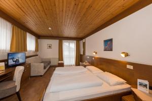 a large room with two beds and a couch at Hotel Mondschein in Sesto