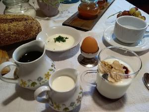 a table with cups of coffee and eggs and bread at Zimmer - Hinterwalderhof in Mühlbach