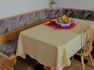 a white table with a bowl of fruit on it at Zimmer - Hinterwalderhof in Mühlbach +1 photo