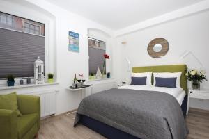 een slaapkamer met een bed en een groene stoel bij Apartamenty Via Mare in Ustka