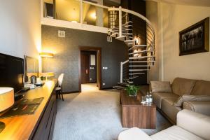 a living room with a spiral staircase and a couch at Rado Resort Spa & Wellness in Mielec
