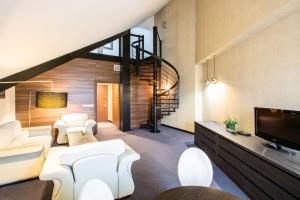 ein Wohnzimmer mit weißen Möbeln und einer Treppe in der Unterkunft Rado Resort Spa & Wellness in Mielec