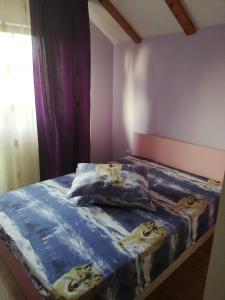 a bedroom with a bed with a blue comforter with cats on it at Casa Tătar in Braşov