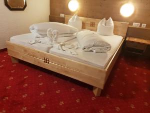 1 dormitorio con 2 camas con sábanas y almohadas blancas en Hotel Reitherhof, en Reith bei Seefeld