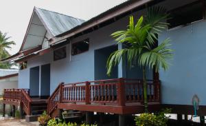 a house with a palm tree in front of it at Dokchampa Guesthouse in Ban Khon