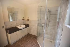 a bathroom with a sink and a shower at The Shingles Riverside Cottages in New Norfolk +21 photos