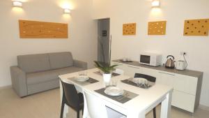 uma cozinha e sala de estar com uma mesa e um sofá em Casa Naiadi em Valledoria