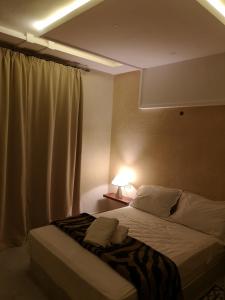 ein Schlafzimmer mit einem Bett mit einer Lampe in der Unterkunft My Home Mirelft in Mirleft