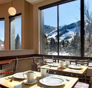 a dining room with tables and chairs and a large window at Hotel Aspen in Aspen