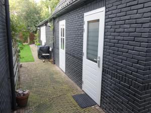 a black brick building with a white door and a walkway at Pelt 35 in Bergen