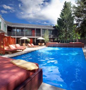 a pool with a couch and chairs in front of a building at Hotel Aspen in Aspen