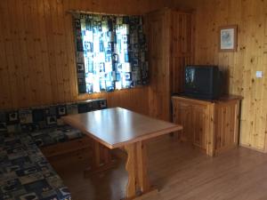 drewniany pokój ze stołem i telewizorem w obiekcie Casitas Cinco Castaños w mieście Candelario