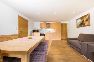 een keuken en een woonkamer met een houten tafel en een bank bij Hieserhof in Neustift im Stubaital