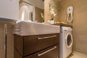 a bathroom with a sink and a washing machine at Corderie de la Tana Biennale Exhibition @Arsenale in Venice