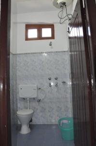 a bathroom with a toilet and a shower at Hotel The Oak in Tawang