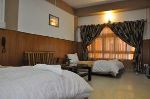 ein Hotelzimmer mit 2 Betten und einem Tisch in der Unterkunft Hotel The Oak in Tawang