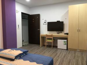 a room with a desk with a monitor and a computer at Meow Meow Fish B&B in Baisha +10 photos