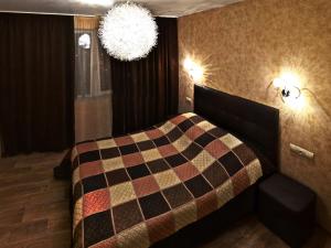a bedroom with a bed with a checkered blanket at ApartLux 3 in Chernihiv