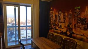 a dining room with a table and a large window at ApartLux 3 in Chernihiv