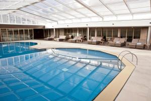 a large swimming pool in a building with chairs at WestCord Strandhotel Seeduyn in Oost-Vlieland