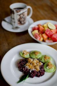 um prato de comida com fruta e uma chávena de café em Teja Home Stay em Ubud