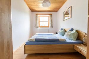 1 dormitorio con cama con sábanas azules y ventana en Landhaus Katharina, en Bischofshofen