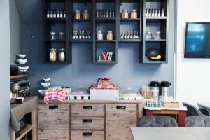 a kitchen with black cabinets and a wooden dresser at Quentin England Hotel in Amsterdam
