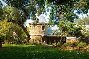 a large stone building with a tree in the yard at Grand Cru Estate Homestead in Springton