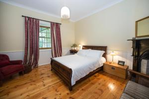 a bedroom with a bed and a couch and a fireplace at Grand Cru Estate Homestead in Springton