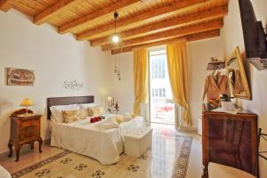 um quarto com uma cama e uma grande janela em "Suliscenti" Dimora Siciliana B&B em Avola