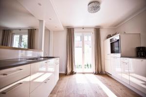 a kitchen with white cabinets and a large window at Ferienhaus Hotel Hirschen Horn in Gaienhofen