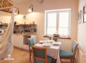 a kitchen and dining room with a table and chairs at Mustármag Vendégház in Noszvaj