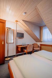 una camera d'albergo con letto, scrivania e TV di Concordia - Wohnen auf Zeit a Francoforte sul Meno