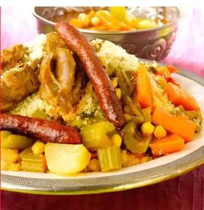 a plate of food with sausage and vegetables on a table at kasbah Ait arbi in Aït Ougliff