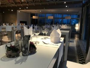 ein Esszimmer mit einem weißen Tisch und Weingläsern in der Unterkunft Hotel-Restaurant & Metzgerei Rößle in Dettingen an der Erms