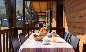 a table with a bowl of fruit on a porch at Camping Esponellà in Esponellá