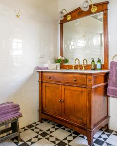 een badkamer met een houten wastafel en een spiegel bij Grand Cru Estate Homestead in Springton