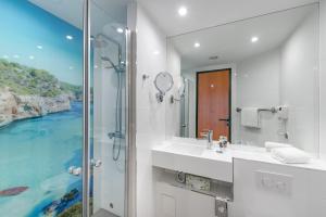 a bathroom with a sink and a shower with a view at Mercure Hotel Düsseldorf Ratingen in Ratingen