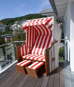 a red and white chair sitting on a deck at Bel Etage in der Villa Amelie am M in Sassnitz