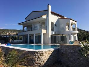 a large white house with a swimming pool at Luxe Villa Livadia, 10 personen in Kandia