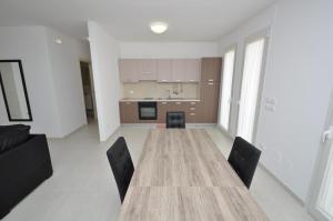 una gran mesa de madera con sillas en la cocina en Vecchia Fabbrica Apartments, en Castrignano deʼ Greci