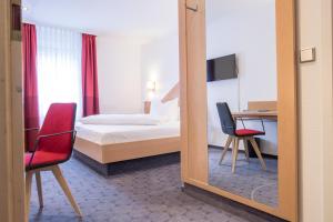ein Hotelzimmer mit einem Bett und einem Spiegel in der Unterkunft Hotel Weißes Roß in Elsterwerda