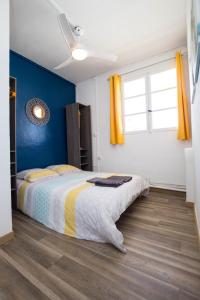 - une chambre avec un lit et un mur bleu dans l'établissement T2 40m² Hypercentre, à Saint-Denis